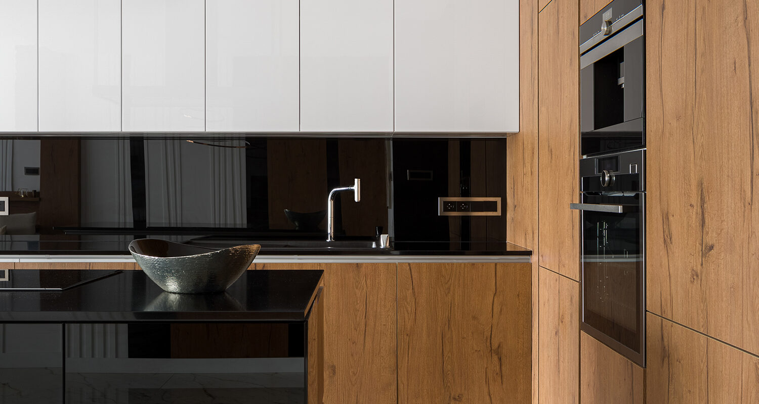 Elegant and stylish kitchen with wooden, black and white cupboards and black countertops and marble floor